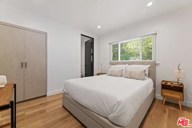 a bedroom with a bed and wooden floor