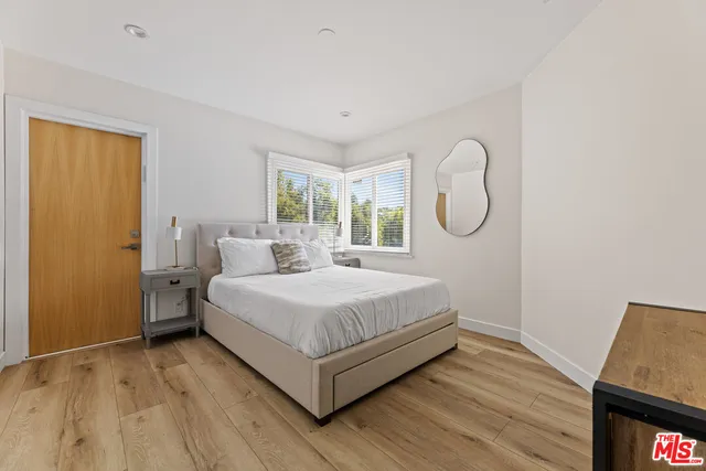 a bedroom with a bed and wooden floor