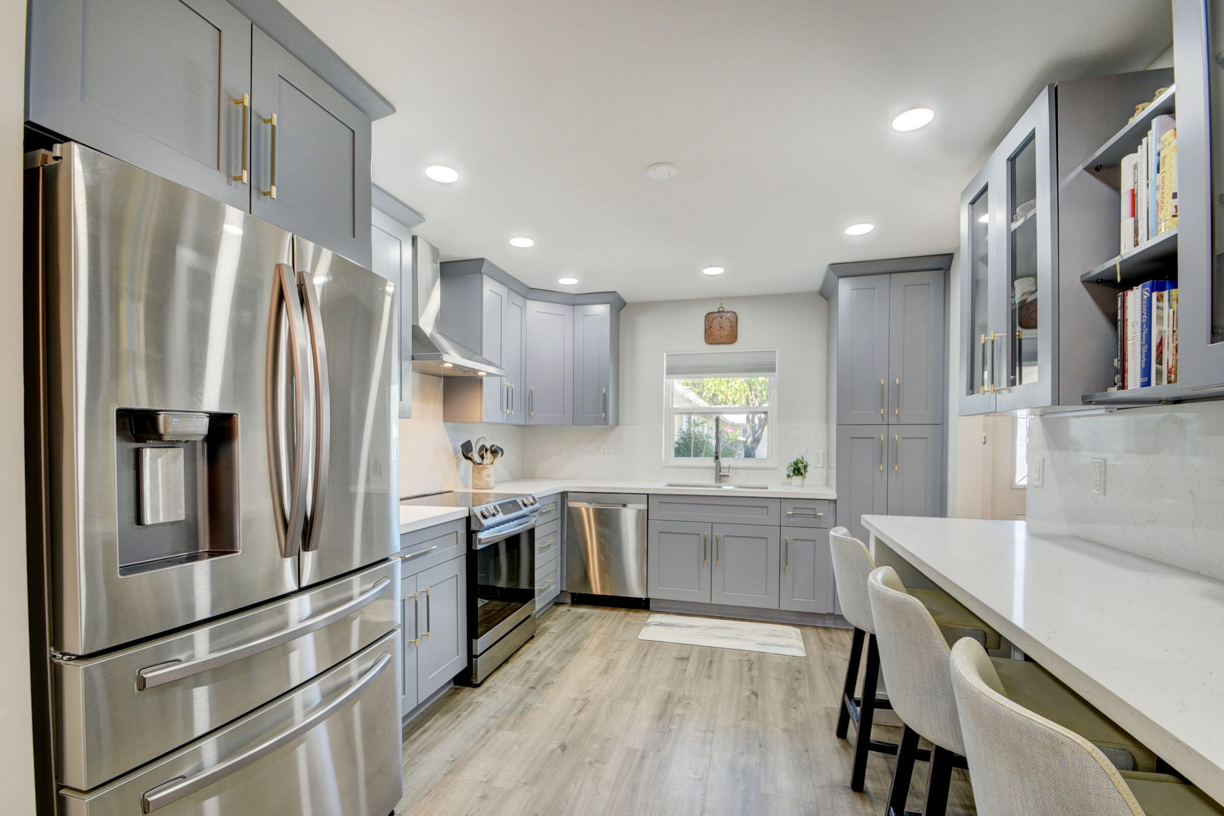 a large kitchen with stainless steel appliances a refrigerator and a stove top oven