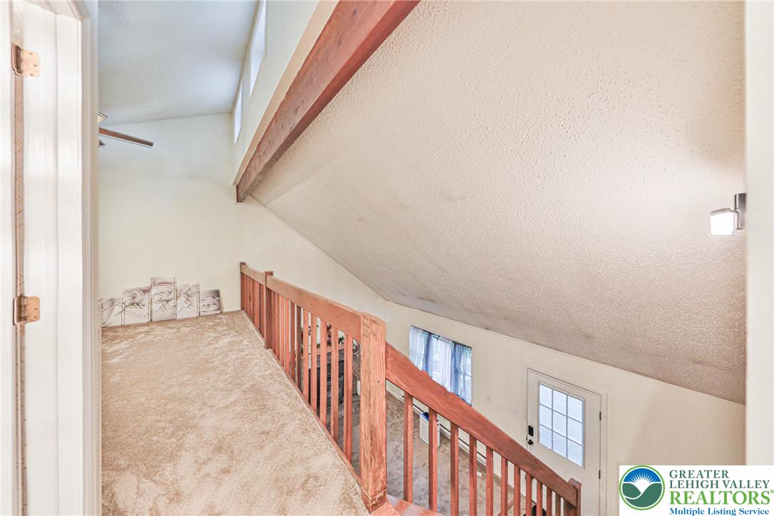 2114 Lakeview Road Bushkill, PA 18324 - Photo 27 of 83 A wooden beam accents the vaulted ceiling above a carpeted loft overlooking the main living area.