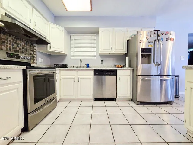 a kitchen with cabinets and steel stainless steel appliances