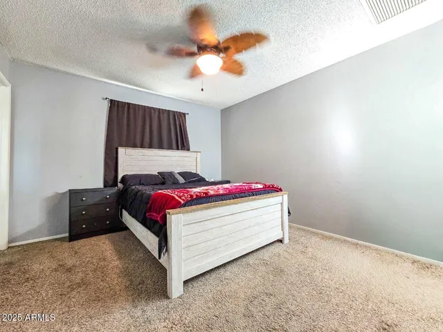 a bedroom with a bed and a ceiling fan