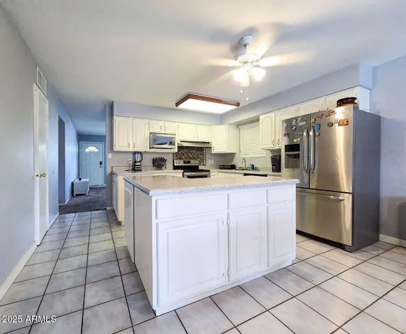 a kitchen with stainless steel appliances a refrigerator sink and microwave