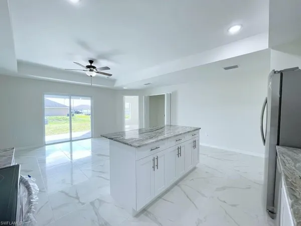 a bathroom with a granite countertop sink a toilet a mirror and bathtub