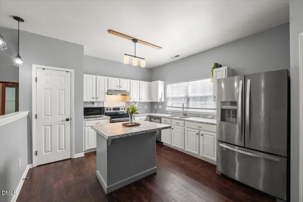 a kitchen with stainless steel appliances a refrigerator sink and cabinets