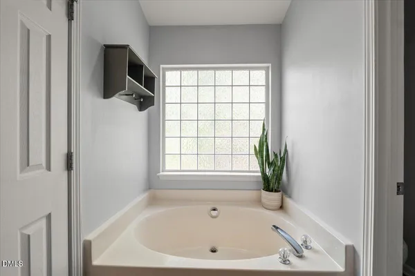 a bathroom with a bathtub and a window