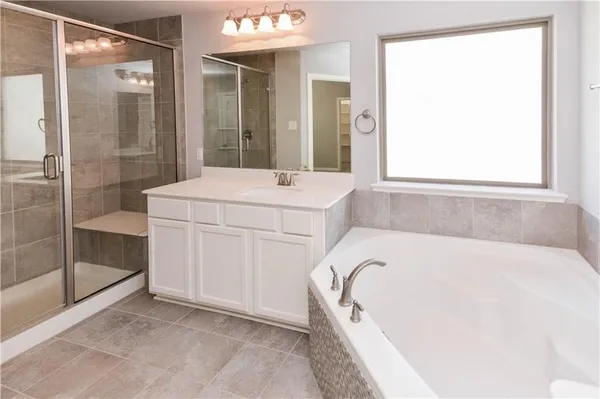 a white bath tub sitting next to a shower