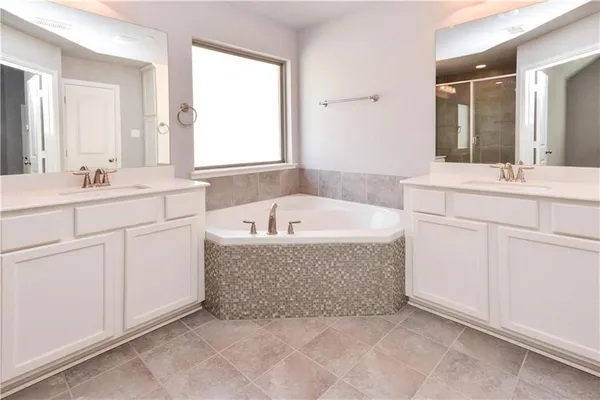 a bathroom with a tub sink and mirror
