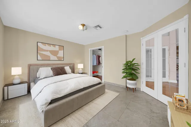 a bedroom with a large bed and a chandelier