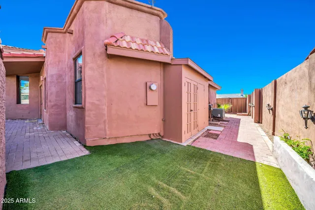 an empty room with wooden floor ceiling fan and windows