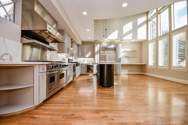 a kitchen with stainless steel appliances granite countertop a stove a sink and a refrigerator