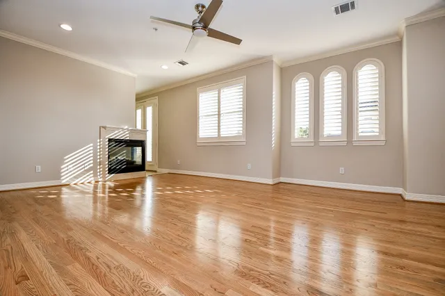 a view of empty room with wooden floor and fireplace