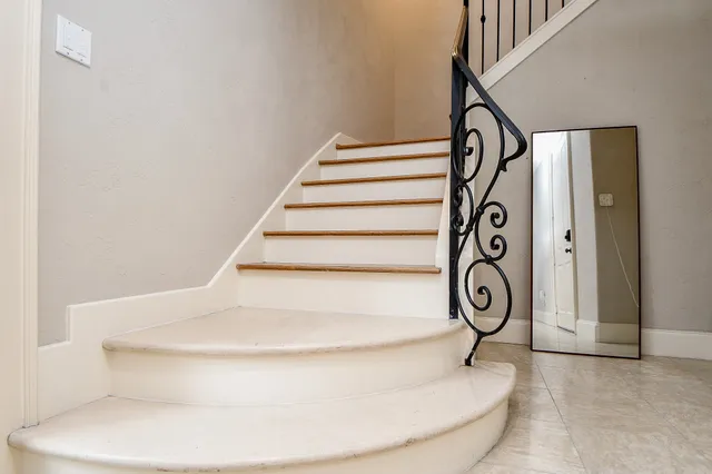 a view of staircase with railing and white walls