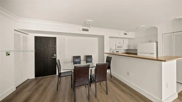 a kitchen with refrigerator cabinets dining table and chairs