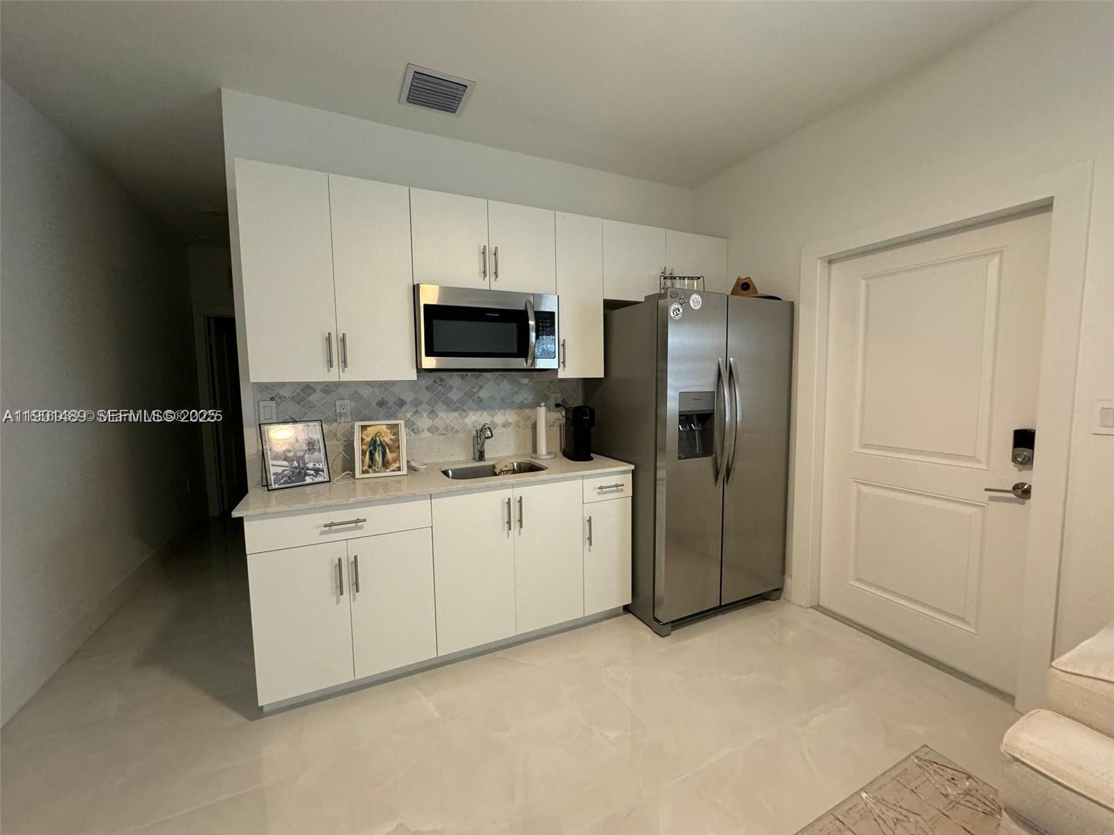 11910 Southwest 243rd Street Homestead, FL 33032 - Photo 7 of 24 a kitchen with stainless steel appliances a refrigerator sink and microwave