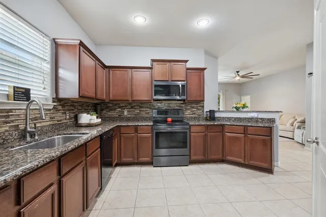 a kitchen with stainless steel appliances granite countertop a stove sink and cabinets