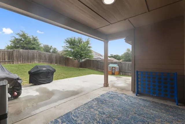 a view of a backyard with table and chairs potted plants with wooden fence