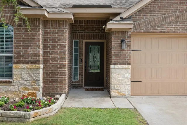 a view of a brick house with potted plants in front of door