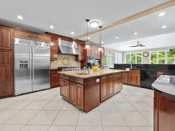 a kitchen with stainless steel appliances granite countertop a stove a sink a refrigerator and cabinets