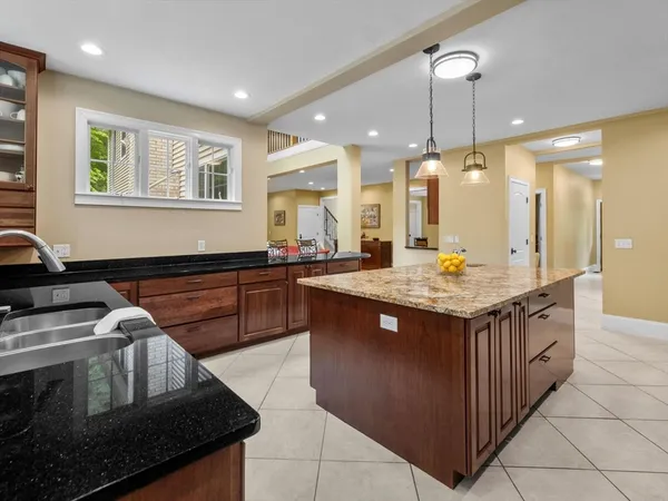 a kitchen with kitchen island granite countertop a stove and a sink
