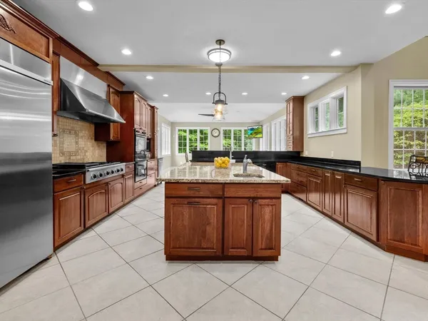 a kitchen with stainless steel appliances granite countertop a stove a sink and a microwave