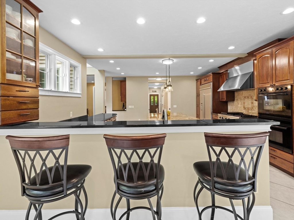 12 Breton Road Upton, MA 01568 - Photo 15 of 42 a kitchen with stainless steel appliances granite countertop a table chairs sink and cabinets