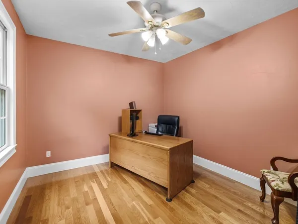 a view of a room with wooden floor and fan
