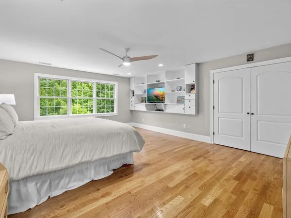 a bed sitting in a spacious bedroom next to a window