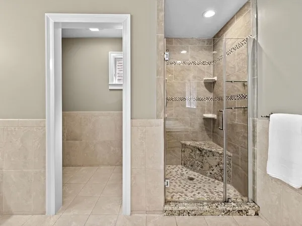 a bathroom with a glass shower door and a mirror