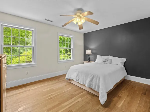a bedroom with a bed chandelier and a window