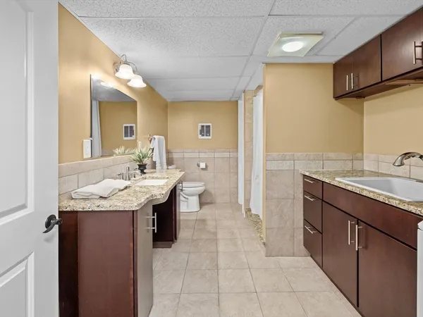 a spacious bathroom with a granite countertop sink and a mirror