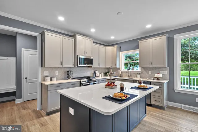 a kitchen with a stove sink and cabinets