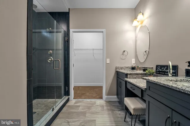 a spacious bathroom with a granite countertop sink a toilet a mirror and shower
