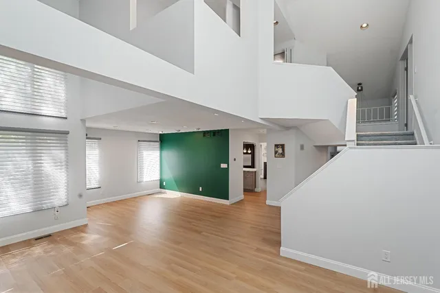 a view of a livingroom with wooden floor and stairs