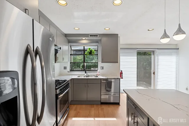 a kitchen with stainless steel appliances granite countertop a sink stove and refrigerator