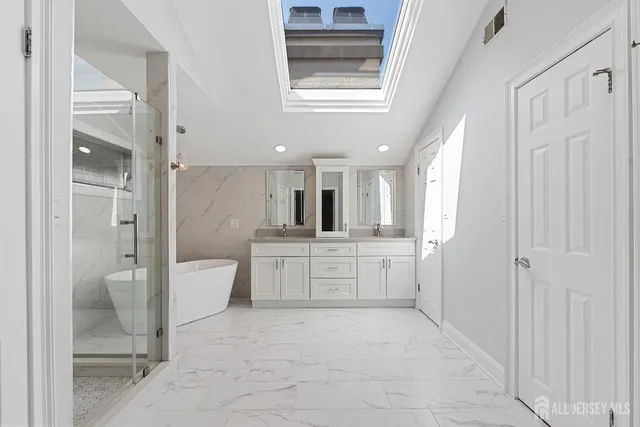 a large bathroom with a granite countertop sink mirror and a bathtub