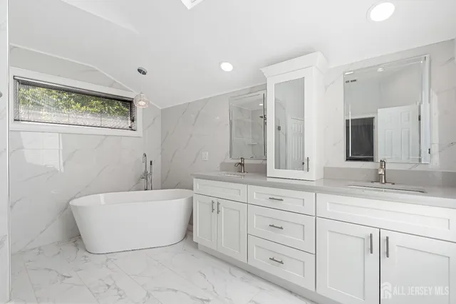 a bathroom with a tub sink and mirror