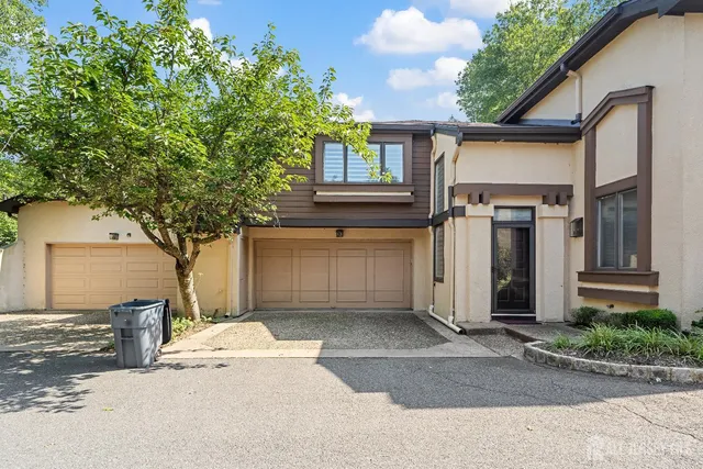 a front view of a house with a tree
