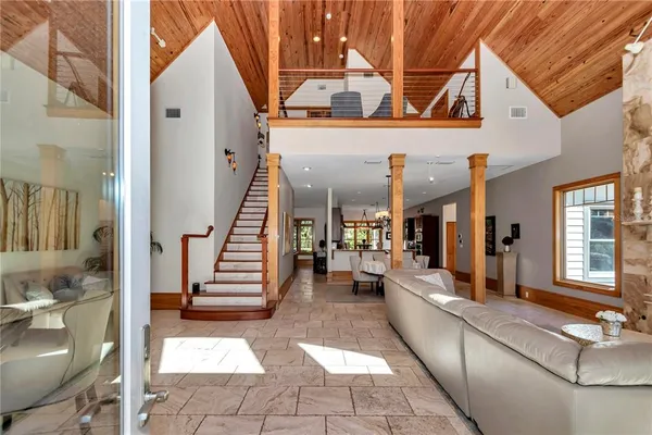 a view of a patio with two couches and deck with wooden floor and fence and a ceiling fan