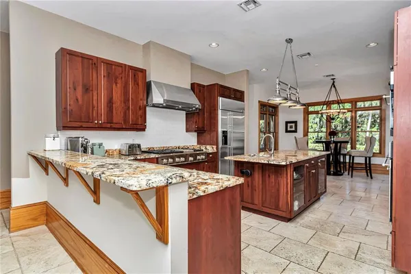 a kitchen with stainless steel appliances granite countertop a sink stove and refrigerator