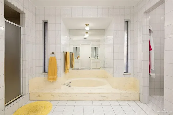 a bathroom with a bathtub shower and a sink