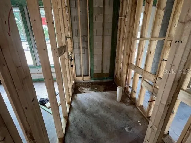 a view of an empty room with wooden floor and windows