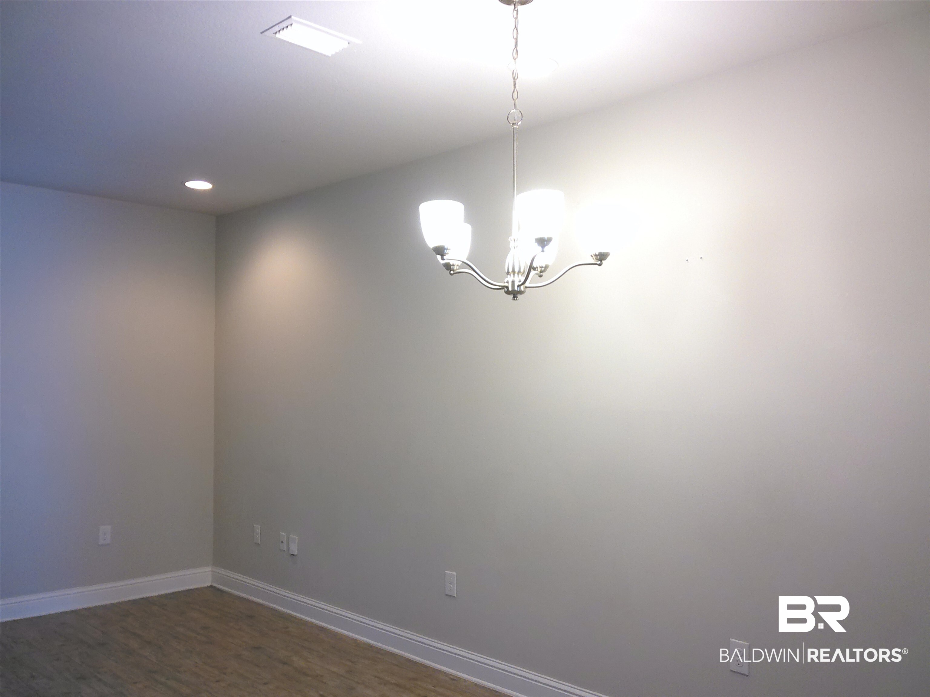 25806 Pollard Road, Unit 23 Daphne, AL 36526 - Photo 3 of 16 Empty room featuring suspended lighting and dark wood finished floors