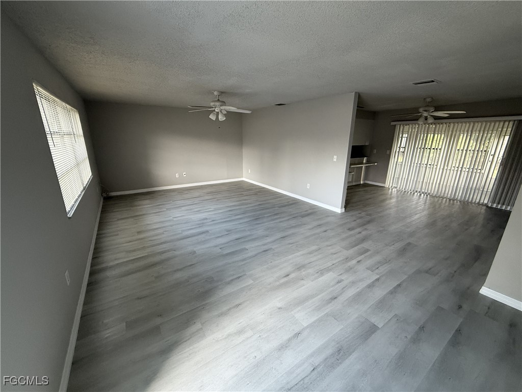 13013 2nd Street Fort Myers, FL 33905 - Photo 3 of 13 an empty room with wooden floor and windows