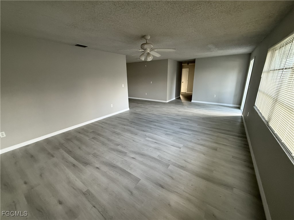 13013 2nd Street Fort Myers, FL 33905 - Photo 4 of 13 wooden floor in an empty room with a window
