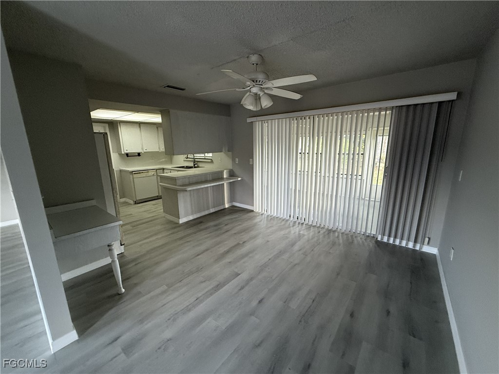 13013 2nd Street Fort Myers, FL 33905 - Photo 5 of 13 a view of a kitchen with wooden floor and a ceiling fan