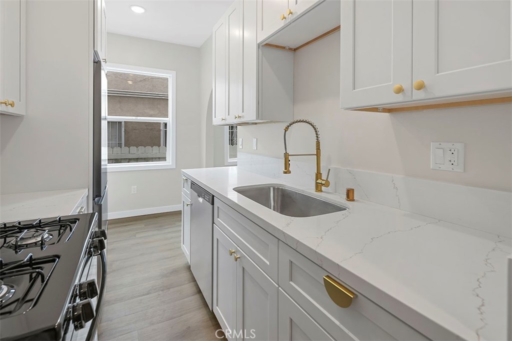 1827 East 4th Street, Unit 7 Long Beach, CA 90802 - Photo 14 of 37 a kitchen with stainless steel appliances a sink and cabinets