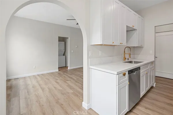 a kitchen with a sink cabinets and wooden floor