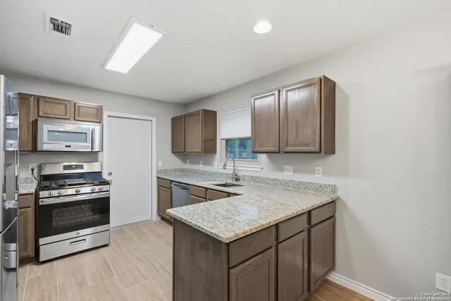 a kitchen with a stove a sink and a refrigerator
