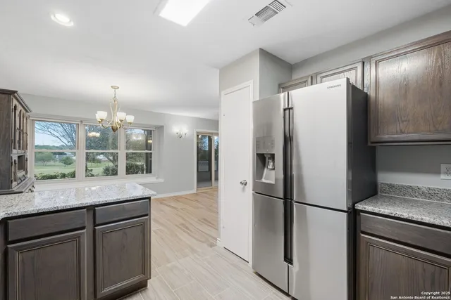 a kitchen with stainless steel appliances granite countertop a refrigerator a stove and a sink